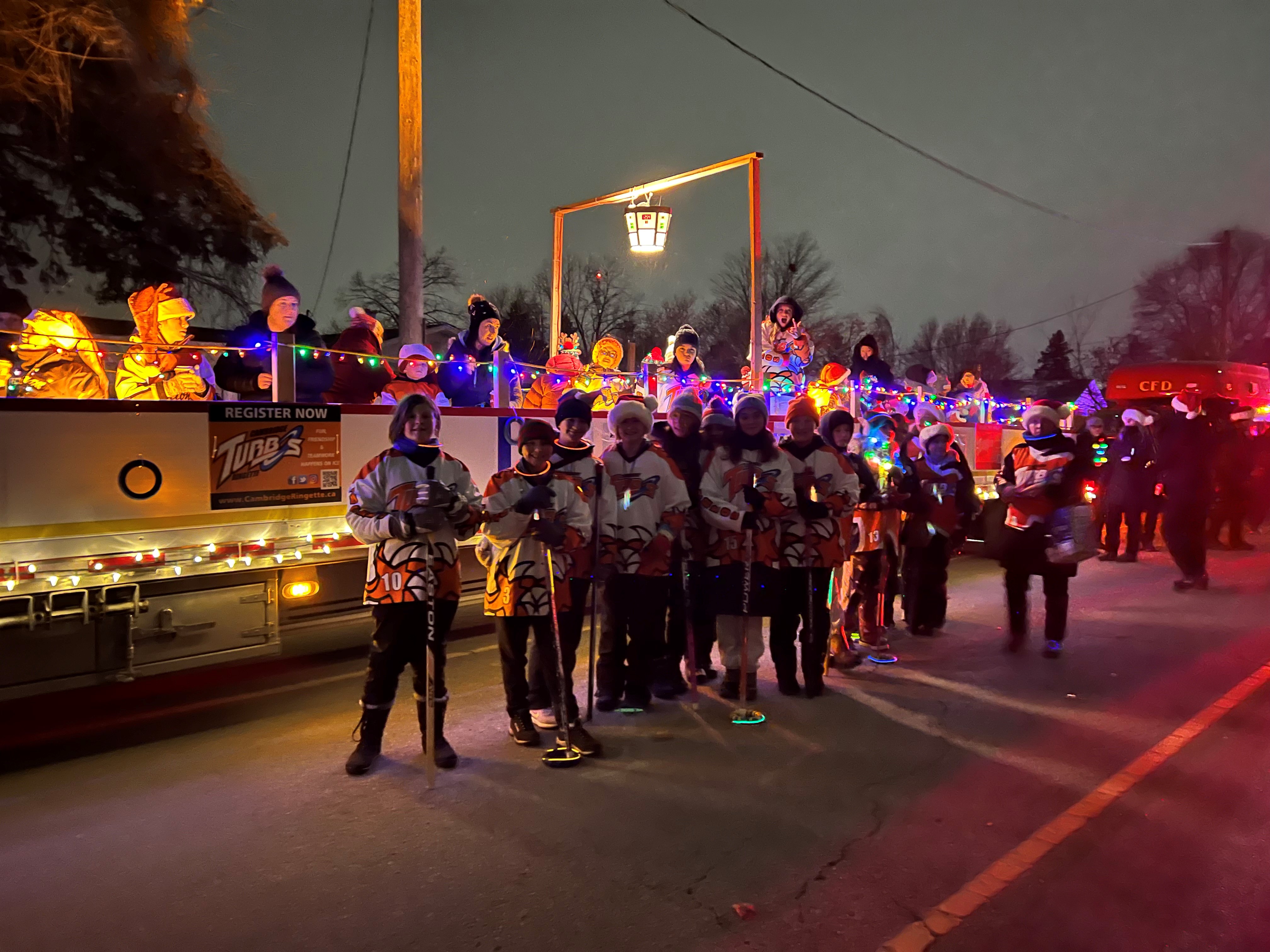 Ringette players in front of parade float